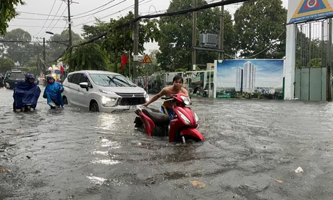 Thành phố Hồ Chí Minh tê liệt vì mưa lớn, người dân bì bõm "lội nước" đi làm