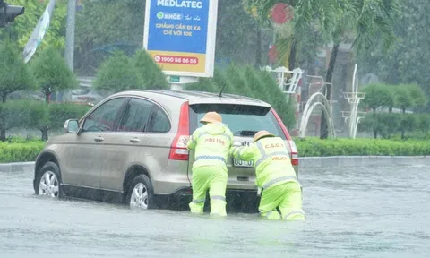 Cảnh sát giao thông căng mình điều tiết xe cộ giữa biển nước sau bão