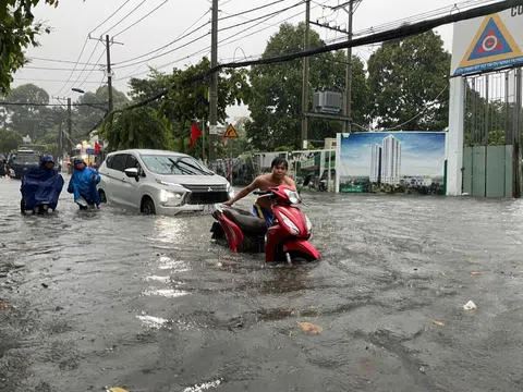 Thành phố Hồ Chí Minh tê liệt vì mưa lớn, người dân bì bõm "lội nước" đi làm