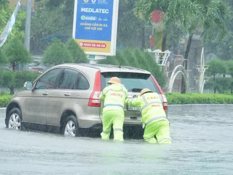 Cảnh sát giao thông căng mình điều tiết xe cộ giữa biển nước sau bão